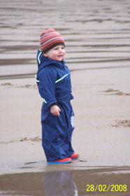 Luke snug and warm in a Puddle suit on a February day at the beach
