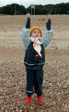 Alex E playing on the winter beach in his Kiba suit