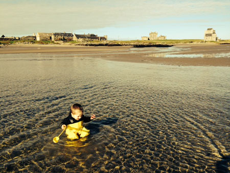Eoghan playing on the beach in his waders